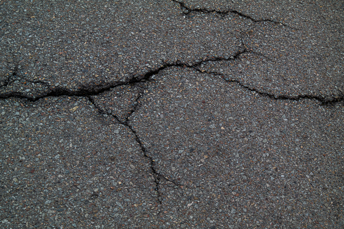 Cracked asphalt road pavement in Cocoa Beach, Florida